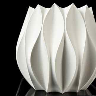 Elegant white 3D paper or ceramic sculpture with intricate petal-like motifs on a dark background.