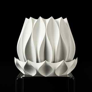Elegant white 3D printed lotus sculpture with intricate petal details, displayed on a transparent stand.