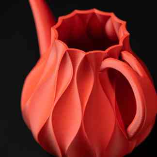 Vibrant orange 3D printed vase with a geometric, sculptural design on a black background.
