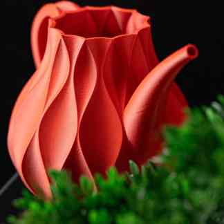 Colorful 3D printed teapot with detailed, textured surface on black background.