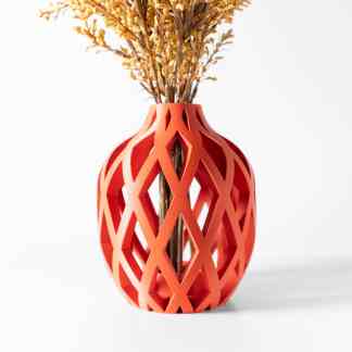 Close-up of a vibrant orange 3D printed vase with geometric lattice design holding dried flowers.