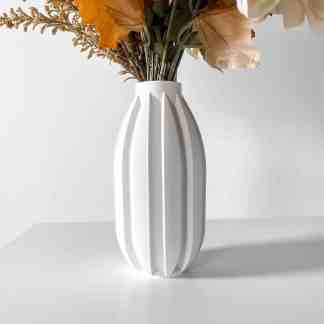 Elegant white vase with a sleek geometric design, filled with artificial flowers for contemporary decor enhancement.