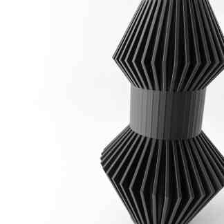 Black 3D printed vase with ribbed, geometric design, highlighting advanced 3D printing techniques.
