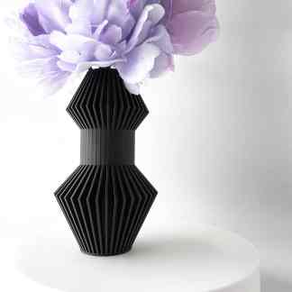 Elegant black 3D printed vase with intricate details, paired with soft purple silk flowers, perfect for contemporary decor.