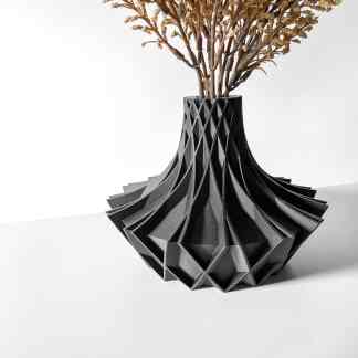 Black geometric 3D-printed vase with intricate lattice design, holding dried flowers.