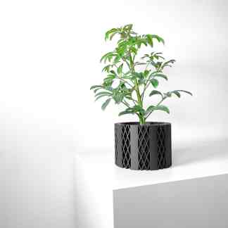 A sleek black 3D printed plant pot holding a green leafy plant, highlighting advanced 3D printing designs.