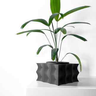 Black sculptural planter with fresh green houseplant on white surface, minimalistic indoor plant decoration.