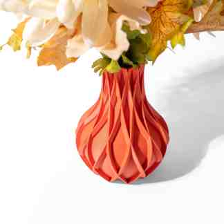 Colorful 3D printed vase with intricate geometric pattern holding artificial flowers.