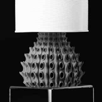 Decorative modern lamp featuring a black textured base and sleek white shade.