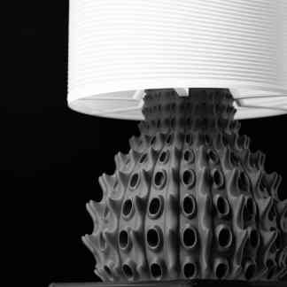 Stunning 3D-printed table lamp with detailed black textured base and sleek white fabric shade, perfect for modern decor.