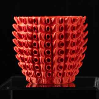 3D printed red vase with intricate geometric design, showcasing advanced additive manufacturing techniques.