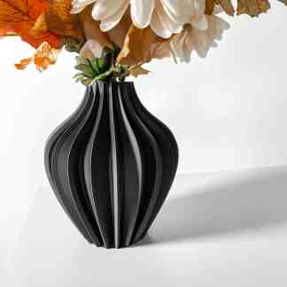 Modern 3D printed black geometric vase with floral arrangement.