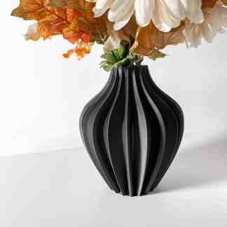 Stylish black 3D printed vase holding artificial flowers, perfect for home decor.