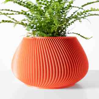 Bright orange ribbed planter with lush green fern, minimalistic background.