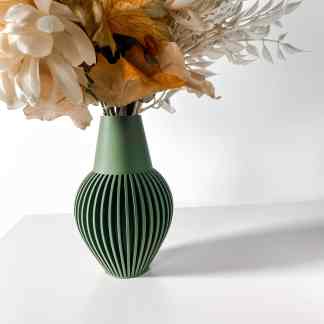 Colorful flowers in stylish green vase against white background.