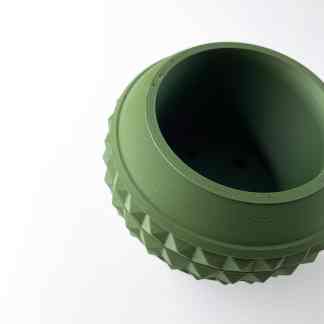 Close-up of a 3D printed green gear with detailed teeth and smooth finish.
