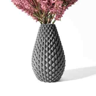 Elegant black vase with a honeycomb pattern holding pink flowers for home decor.