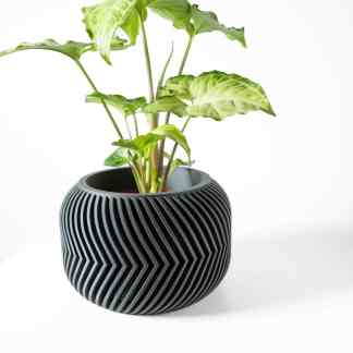 Stylish 3D printed black vase with a lush green plant, perfect for contemporary decor.