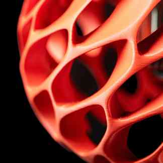 Close-up of innovative 3D-printed geometric structure with orange and red flexible filament.