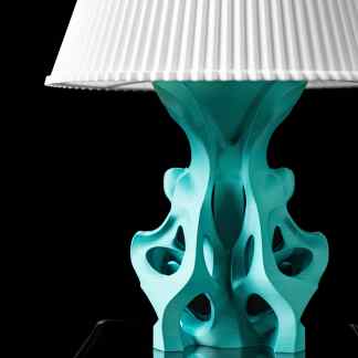 Vibrant teal 3D-printed table lamp with intricate, artistic base and modern white shade, showcasing innovative fabrication.