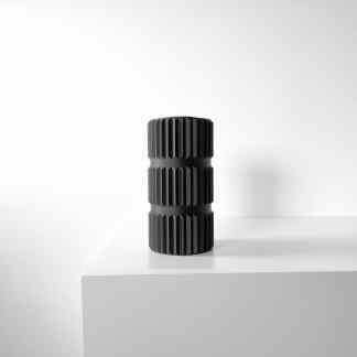 Innovative black 3D-printed geometric sculpture on white stand, modern home decor, artistic design.