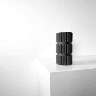 Elegant black 3D-printed geometric sculpture on white surface, modern art decor.