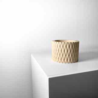 Decorative 3D-printed beige vase with detailed geometric design on a white surface.
