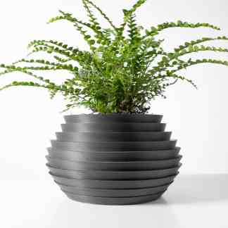 3D printed black flower pot with lush green fern, highlighting modern design and eco-friendly manufacturing.