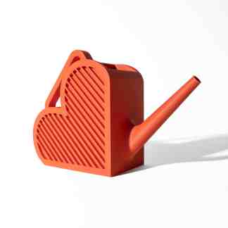 Close-up of a vibrant orange, heart-shaped miniature watering can with a long spout on a white background.