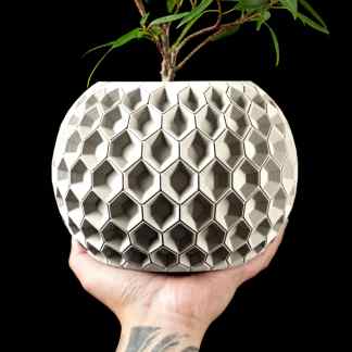 A unique 3D printed plant pot with a geometric honeycomb design, showcasing innovative additive manufacturing technology.