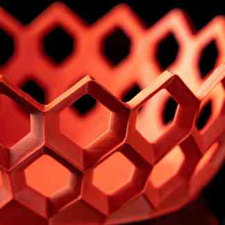 Close-up of a red hexagonal 3D-printed lattice structure.