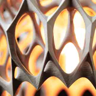 Close-up of intricate 3D-printed geometric pattern with warm backlighting.