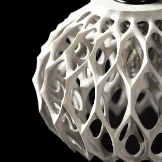 A detailed view of a white, 3D-printed, geometric lattice structure showcasing intricate design and advanced 3D printing technology.