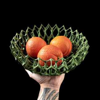 Decorative green honeycomb-style basket holding three oranges, modern reusable fruit container.