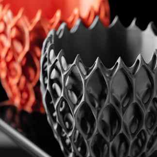 Intricate 3D-printed lattice structures in black and copper, highlighting innovative design and 3D printing technology.