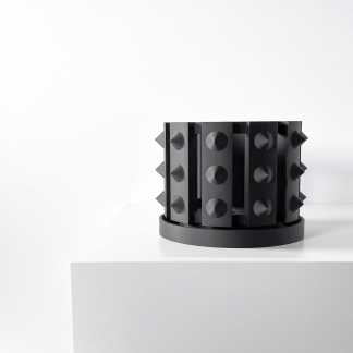 Black geometric 3D printed sculpture with spikes on a white pedestal, modern art piece.