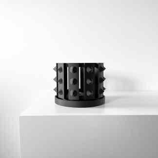 Sleek black 3D-printed art piece featuring cone and spike details on a round base.