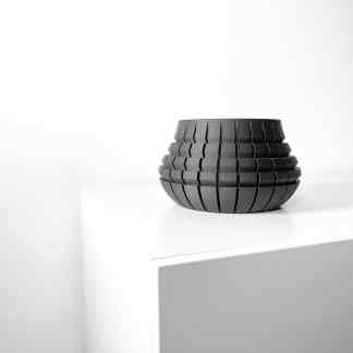 Elegant black 3D-printed vase with geometric patterns on white surface, ultra-modern decor piece.