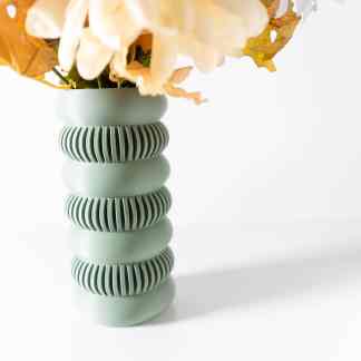 A contemporary mint-green vase with ribbed detailing, perfect for floral arrangements and interior design.