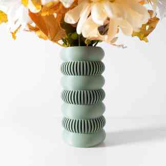 Green decorative vase with textured ribbing, ideal for floral arrangement and modern interior design.