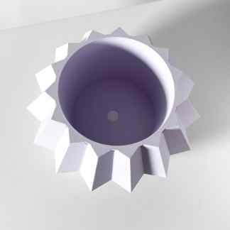 Vivid white 3D printed geometric object with intricate star-like edges for creative decor.