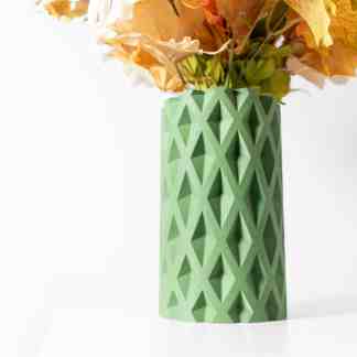 Vase with geometric diamond pattern, 3D printed in green, holding decorative paper flowers.