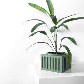 Stylish green potted plant with long, lush leaves in a modern, decorative container on a white surface.