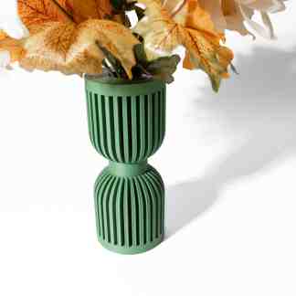 Vibrant green 3D-printed vase with vertical slats holding artificial autumn flowers.