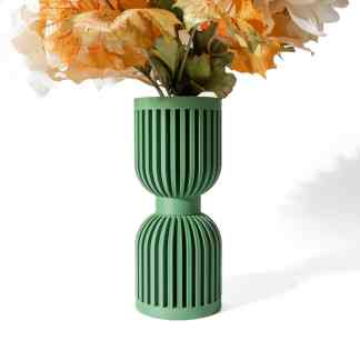 Decorative green vase with vertical grooves and artificial flowers for home interior design.