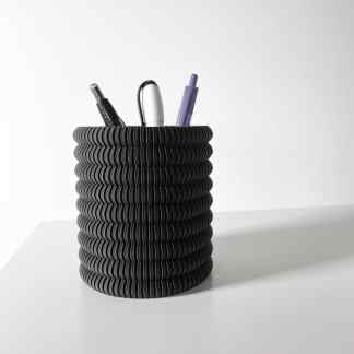 Black textured spiral pen holder with three stylish pens on a plain white background.