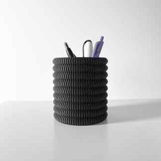 Black creative pen holder with pens and pencils, stylish desk organizer for office or home workspace.