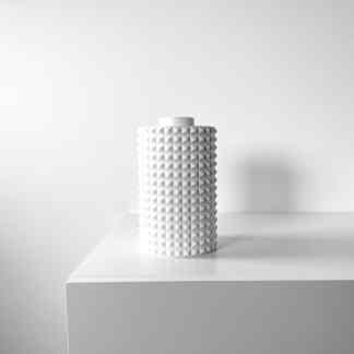 Clean white textured ceramic vase with geometric pattern for contemporary interiors.