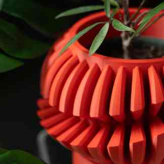 Vibrant orange 3D printed plant pot with unique geometric design, perfect for indoor plants.