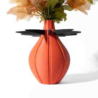 Elegant orange 3D-printed vase holding artificial flowers, showcasing innovative 3D printing technology.